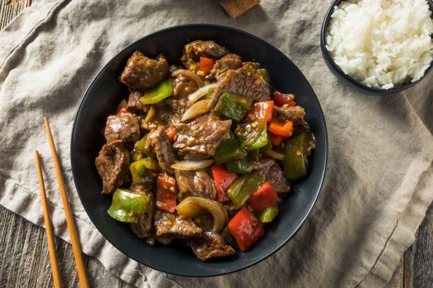 Close-up of pepper steak with colorful bell peppers and onions in a savory brown sauce