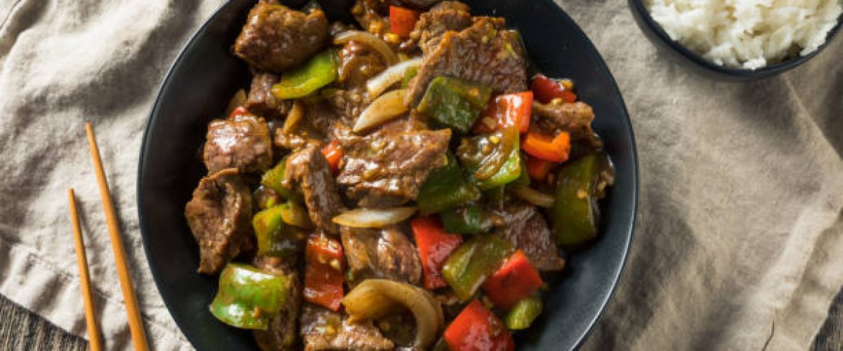 Close-up of pepper steak with colorful bell peppers and onions in a savory brown sauce